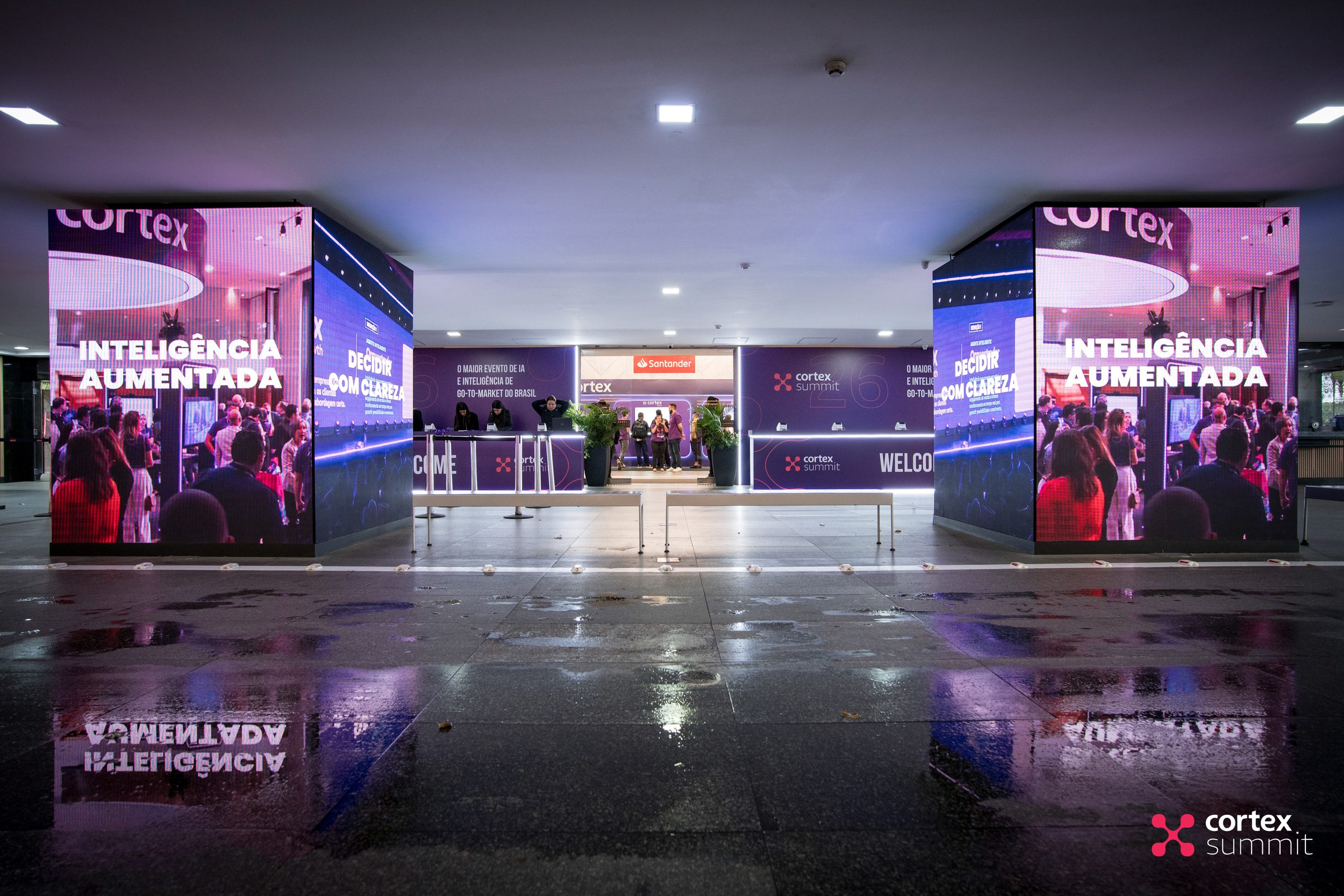 Entrance LED totems showing Inteligência Aumentada above the registration area