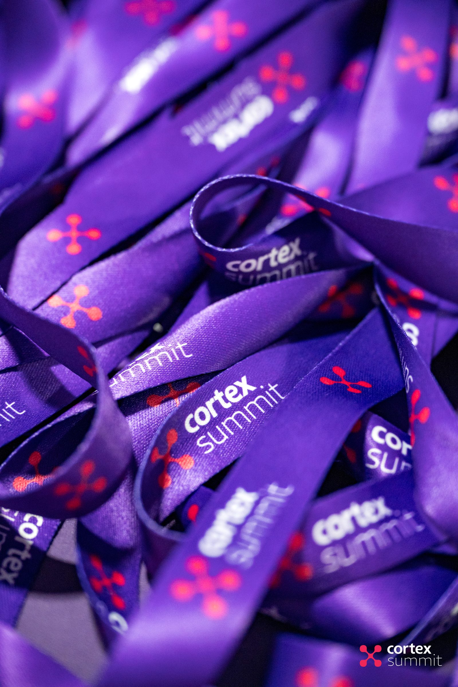 Pile of purple Cortex Summit lanyards printed with the event logo